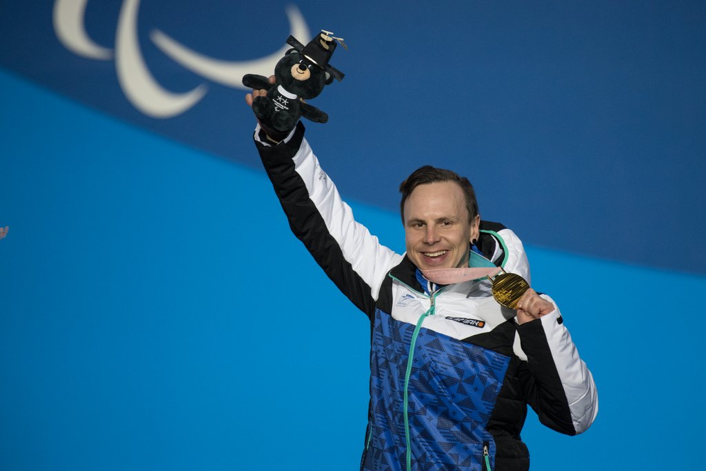 Matti Suur-Hamari tuulettamassa lumilautacrossin mitaliseremoniassa hopeamitali kaulassaan ja kisamaskotti kädessään Pyeongchangissa 2018.